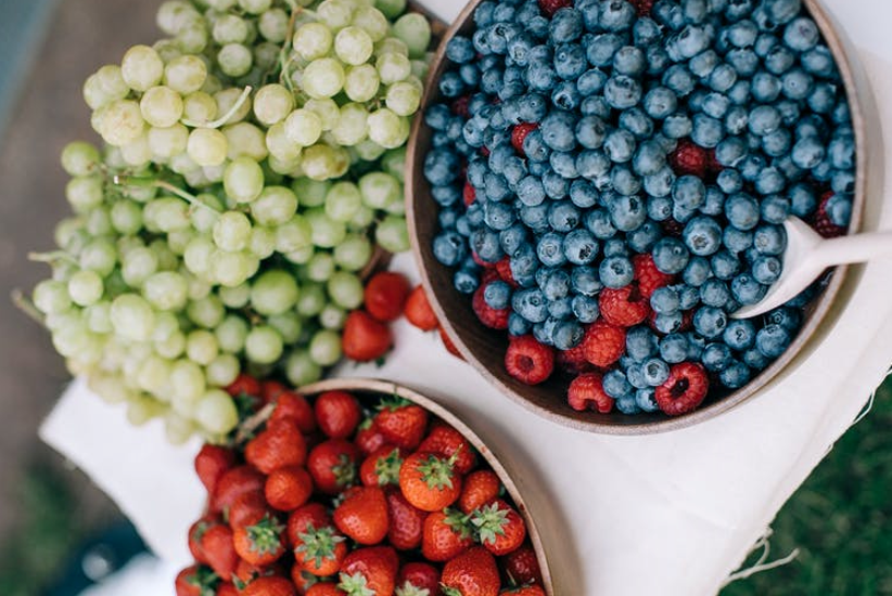 Bowl of strawberries, blueberries, raspberries and green grapes.