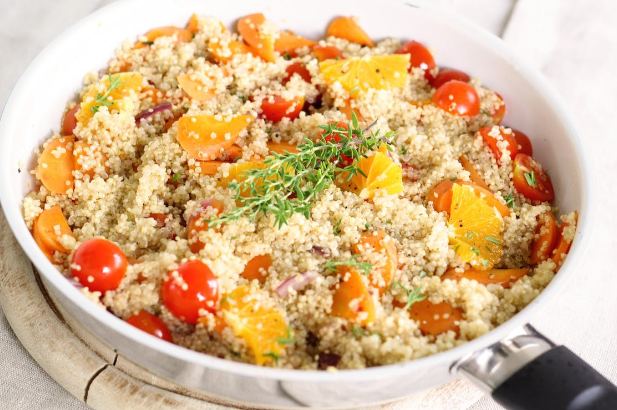 Healthy quinoa salad with cherry tomatoes, peppers and oranges.