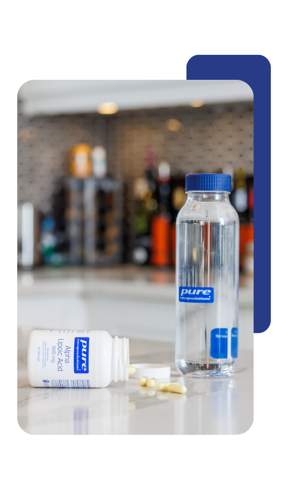 Pure Encapsulations water bottle, supplement bottle and pills.
