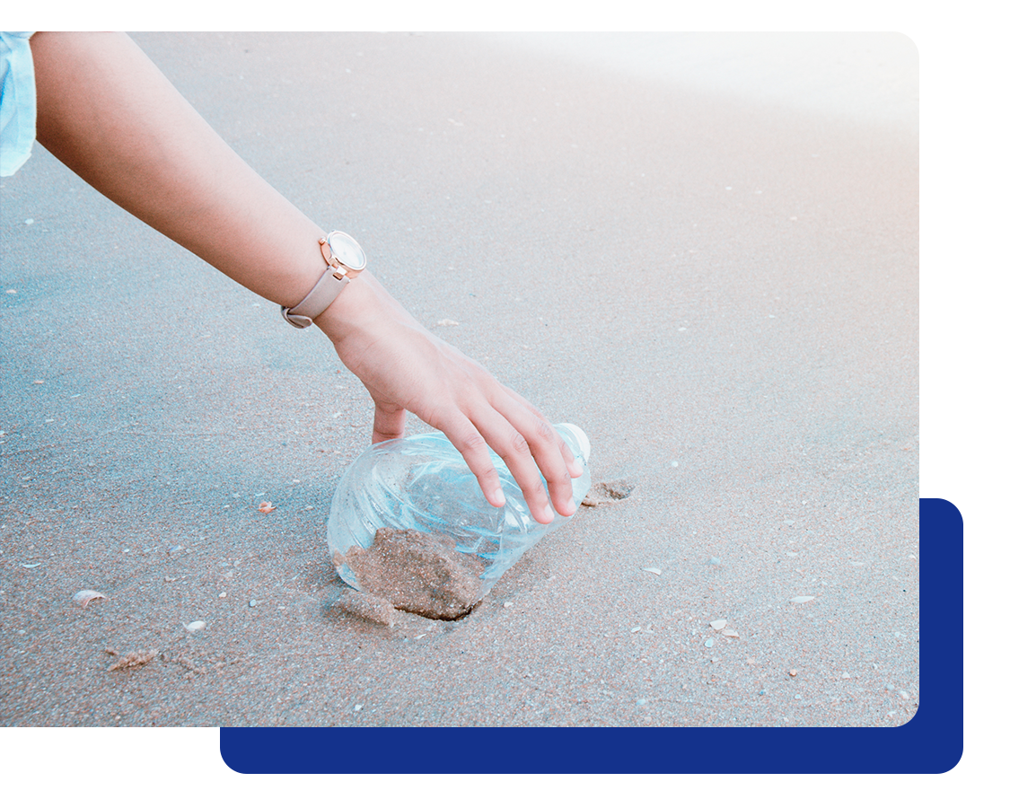 plastic-bottle-in-hand Picking up a plastic bottle from the beach.