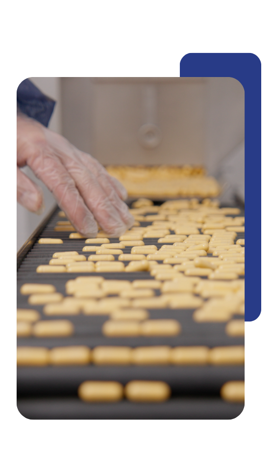 Product testing A hand reaching out to organize items on a conveyor belt part of the operations procedure.