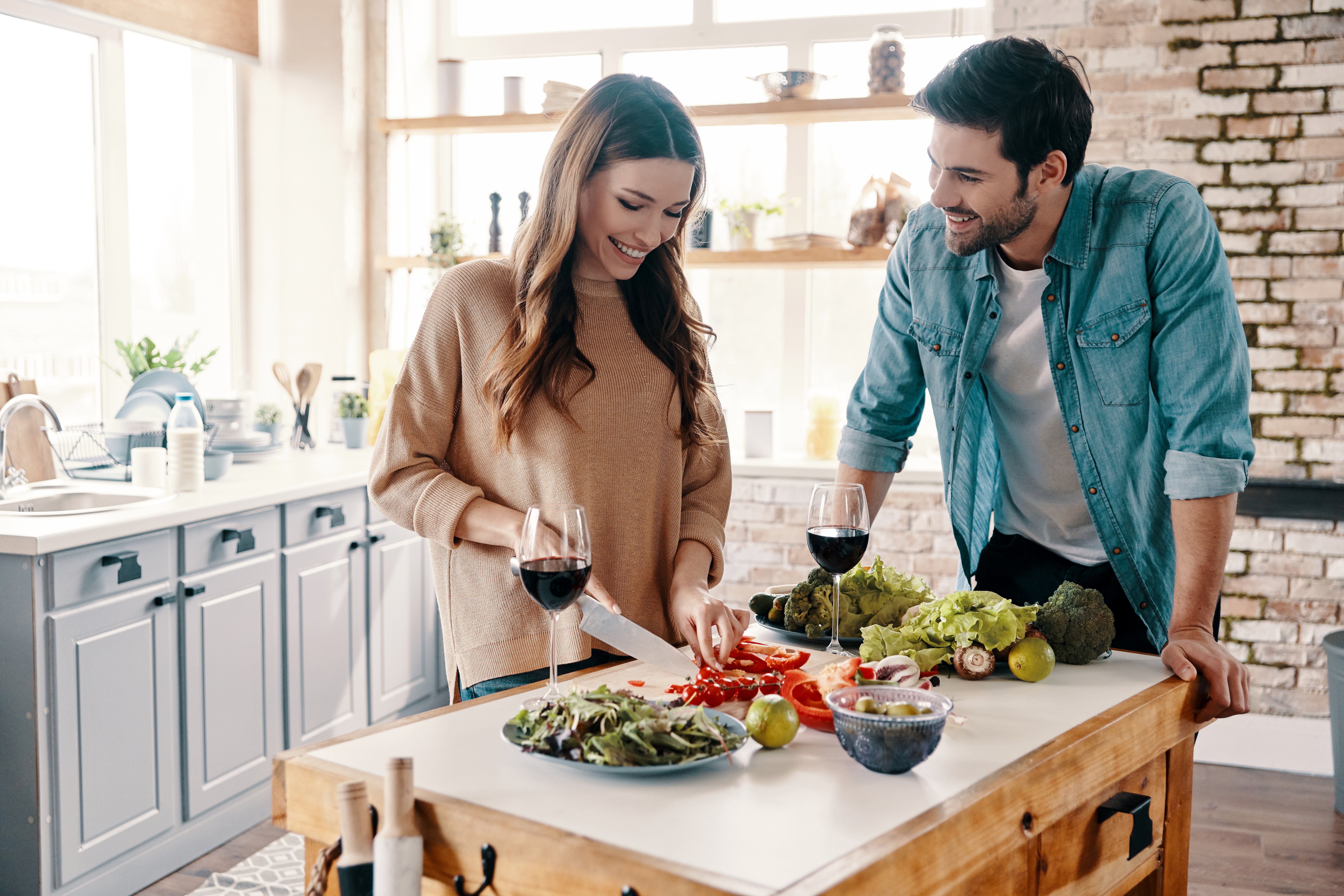 un-mari-et-une-femme-cuisinant-dans-la-cuisine-et-souriant
