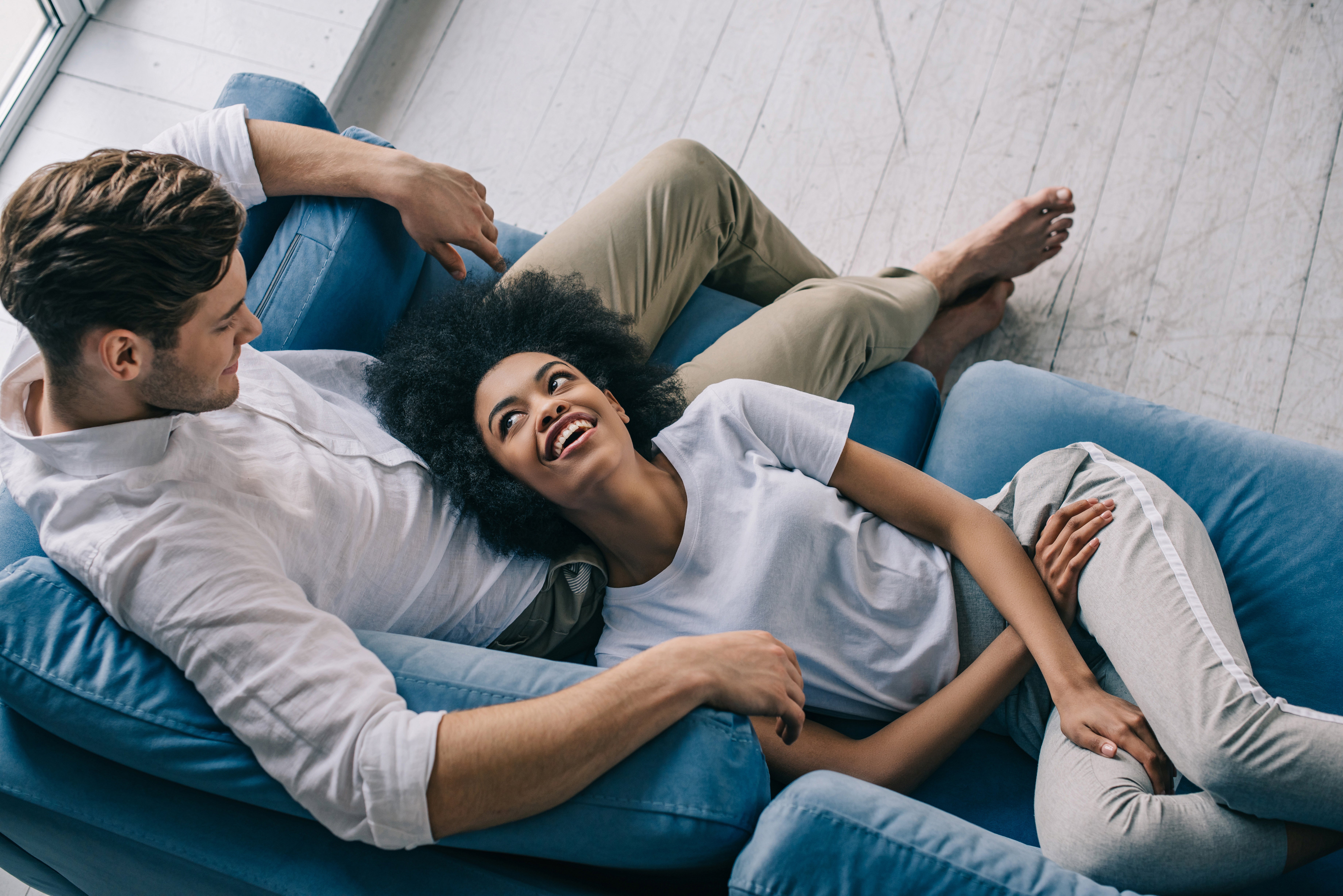 a-happy-couple-relaxing-on-the-couch-and-smiling