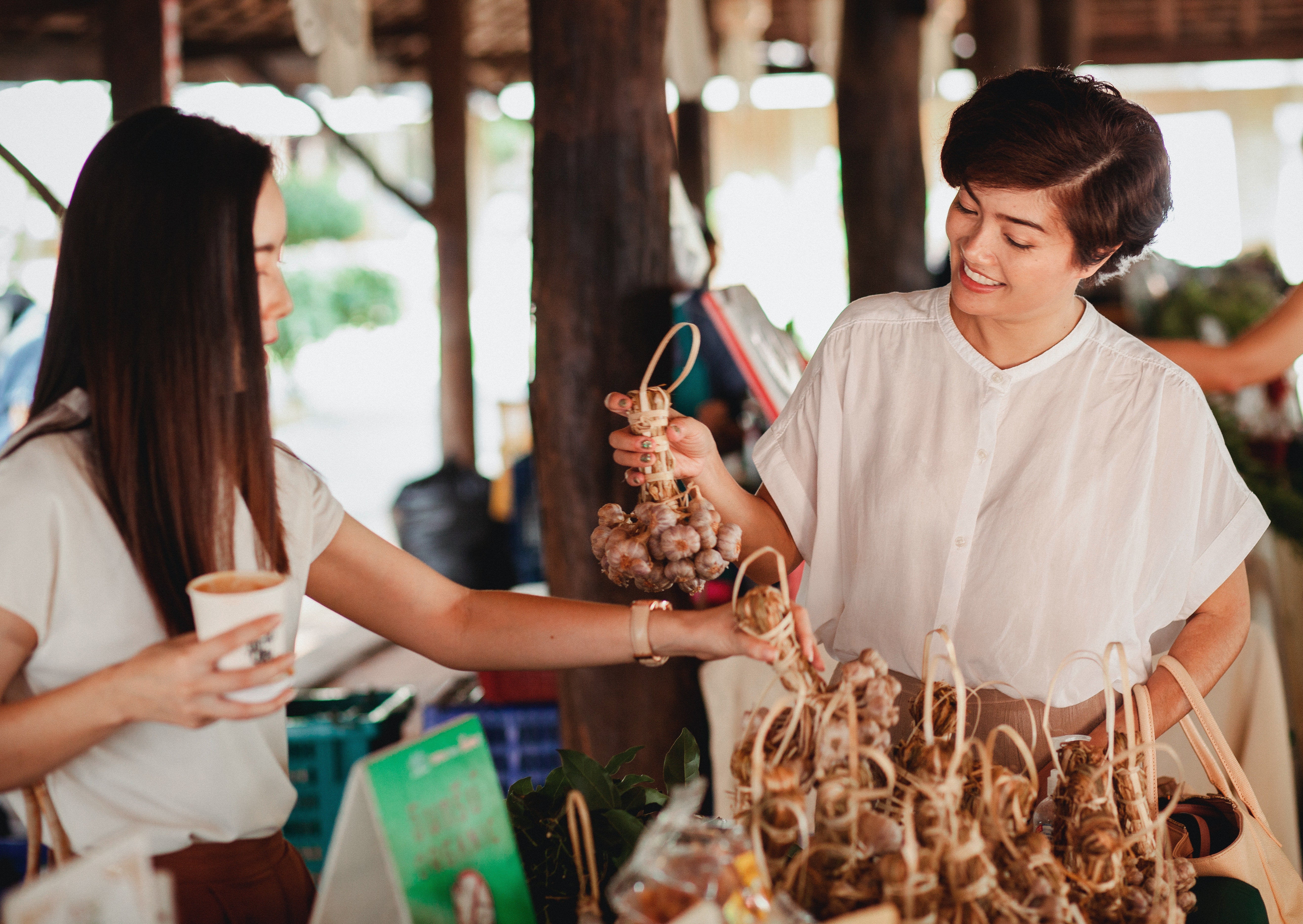 two-women-at-an-outdoor-market-shopping-and-smiling