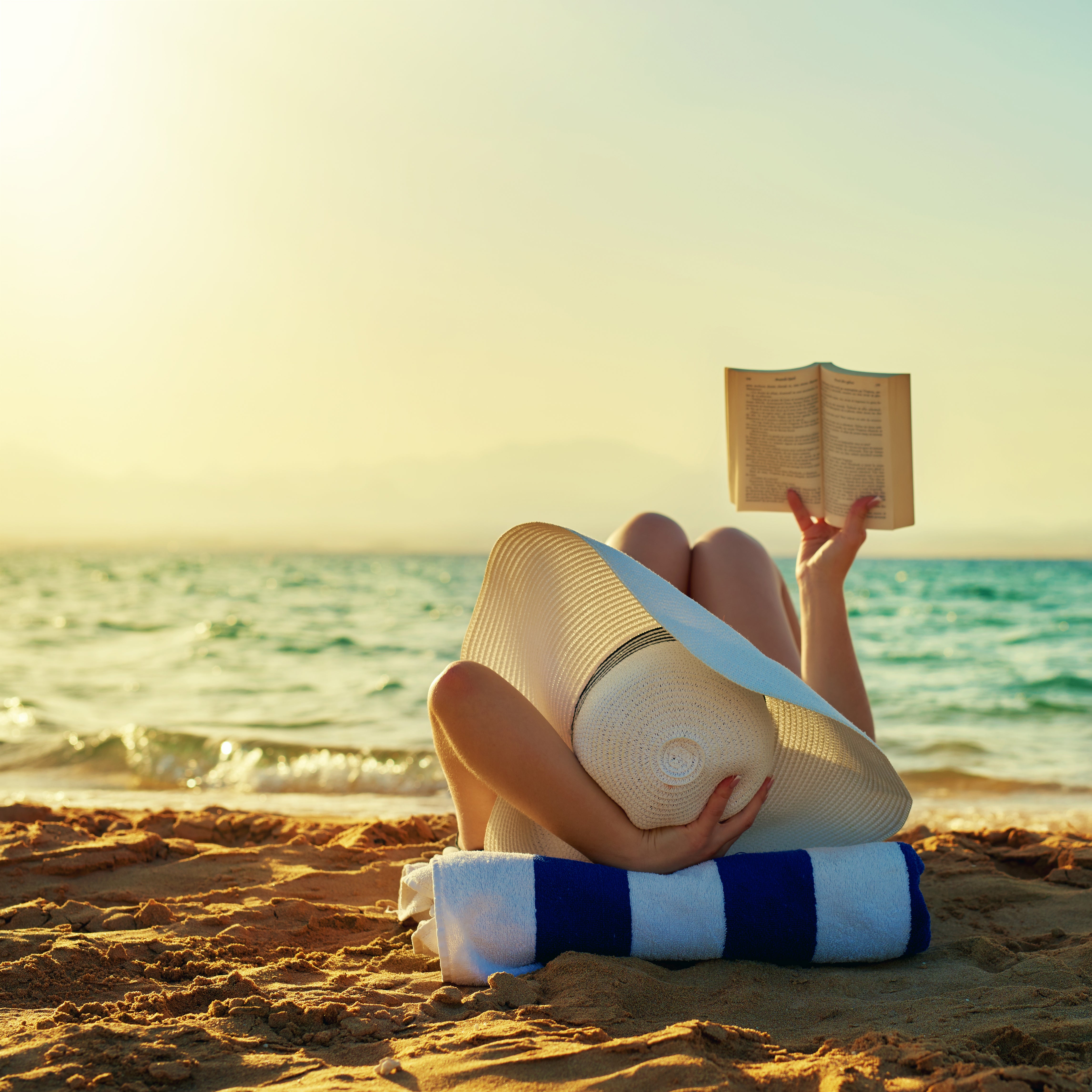 a-women-enjoying-the-beach-and-reading-a-book-by-the-water