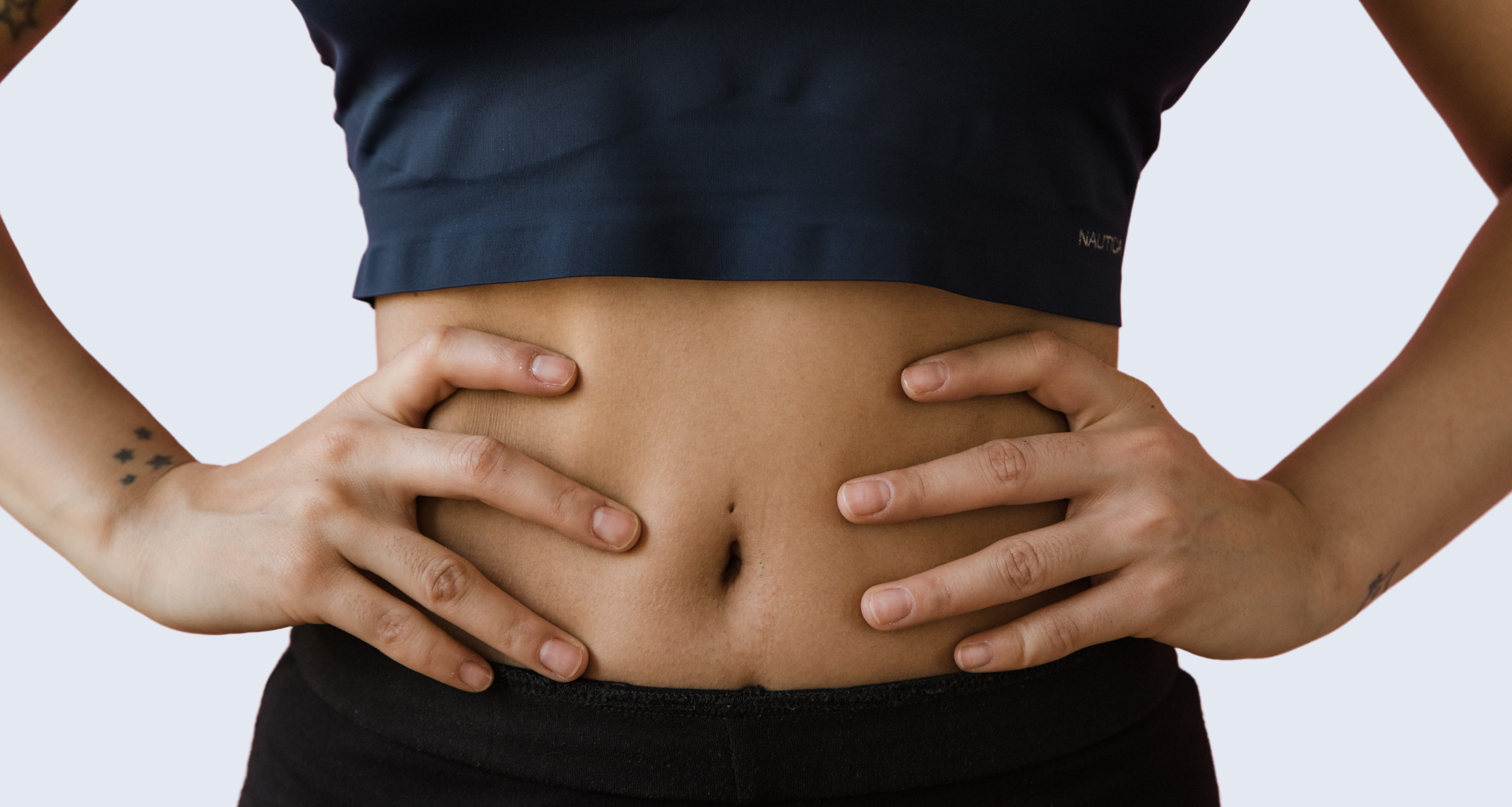 Women's abdominal and her hands are on her waist