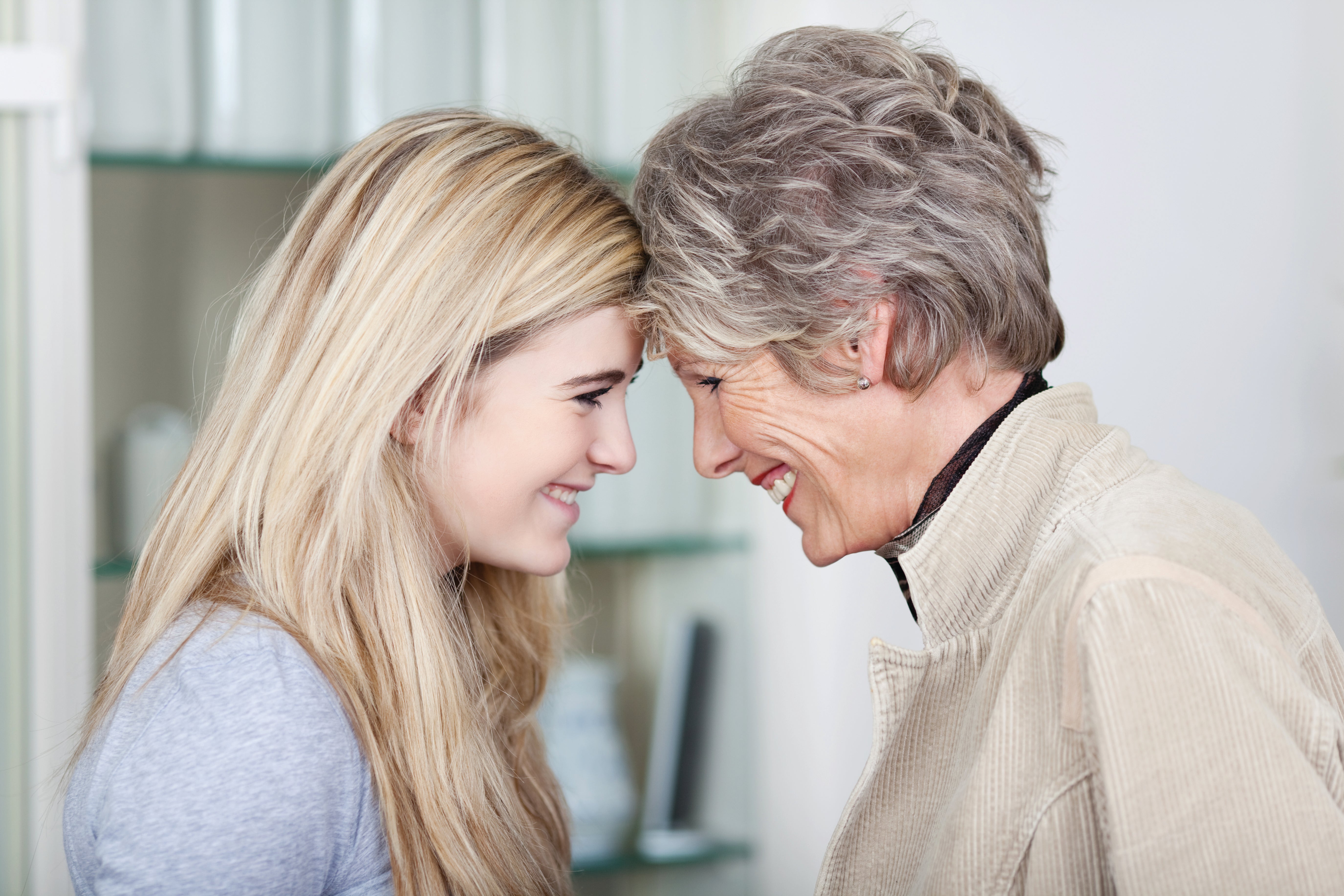Grandmother and granddaughter touching foreheads and smiling