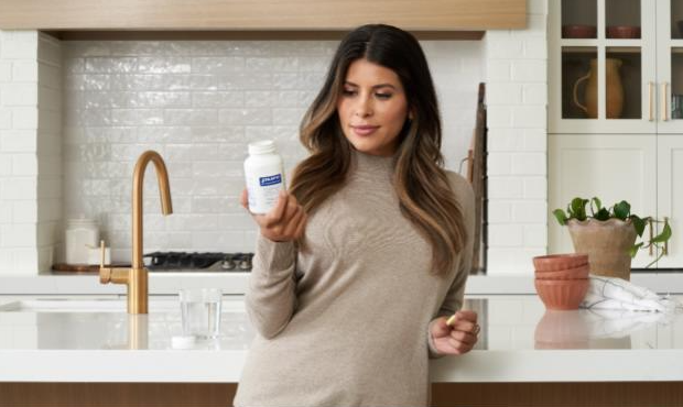 Women holding her Pure Encapsulations supplement bottle