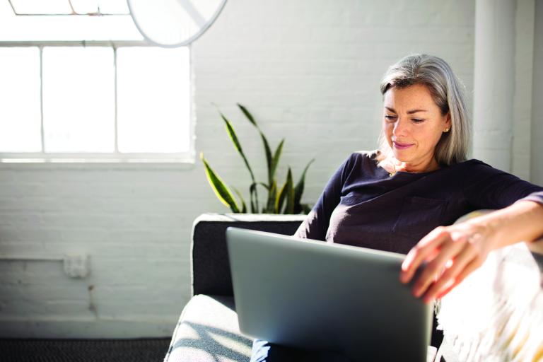 Femmes assises sur un canapé avec un ordinateur portable