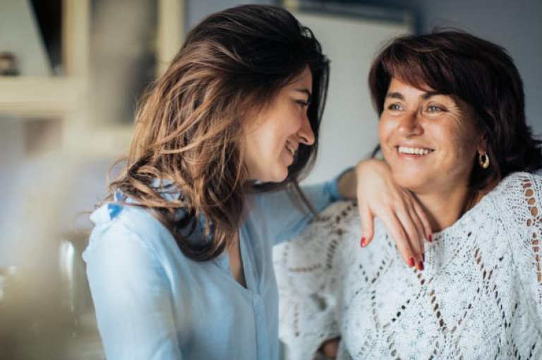 A mother and daughter smiling together