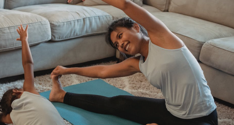 Mother and daughter stretching at home