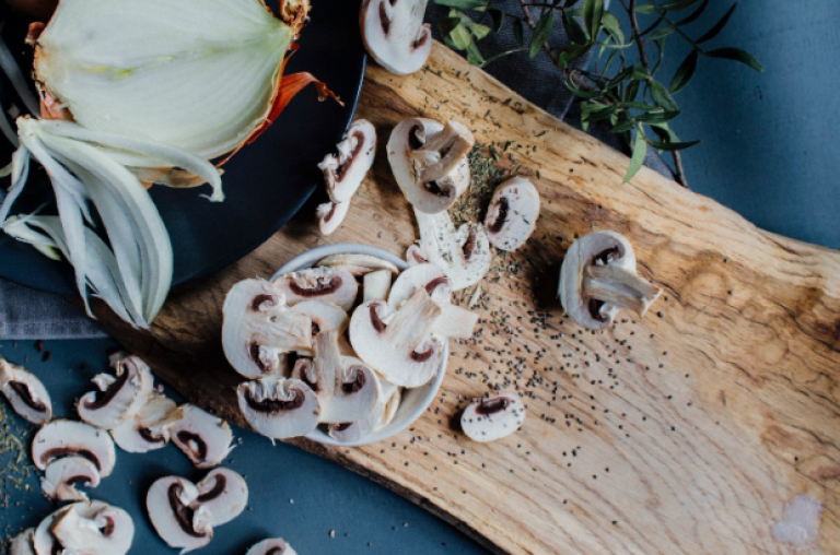 Oignons et champignons sur une planche à découper en bois