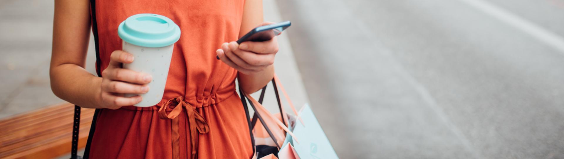 Women with coffee and texting outside