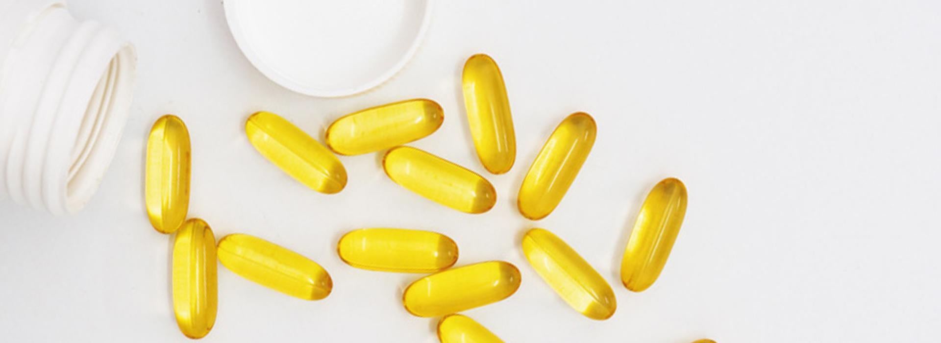 Vitamin supplements coming out of a supplement bottle