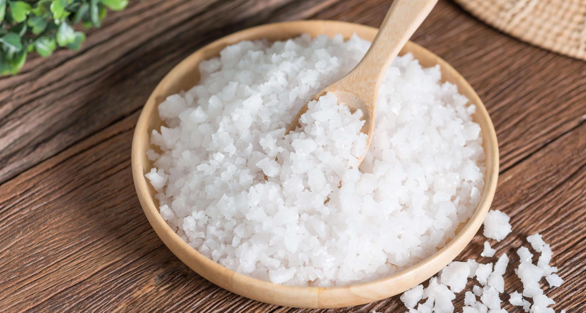 Himalayan salt in a small dish on a wooden cutting board.