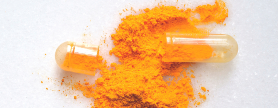 An open supplement capsule with the vitamin powder contents visible.